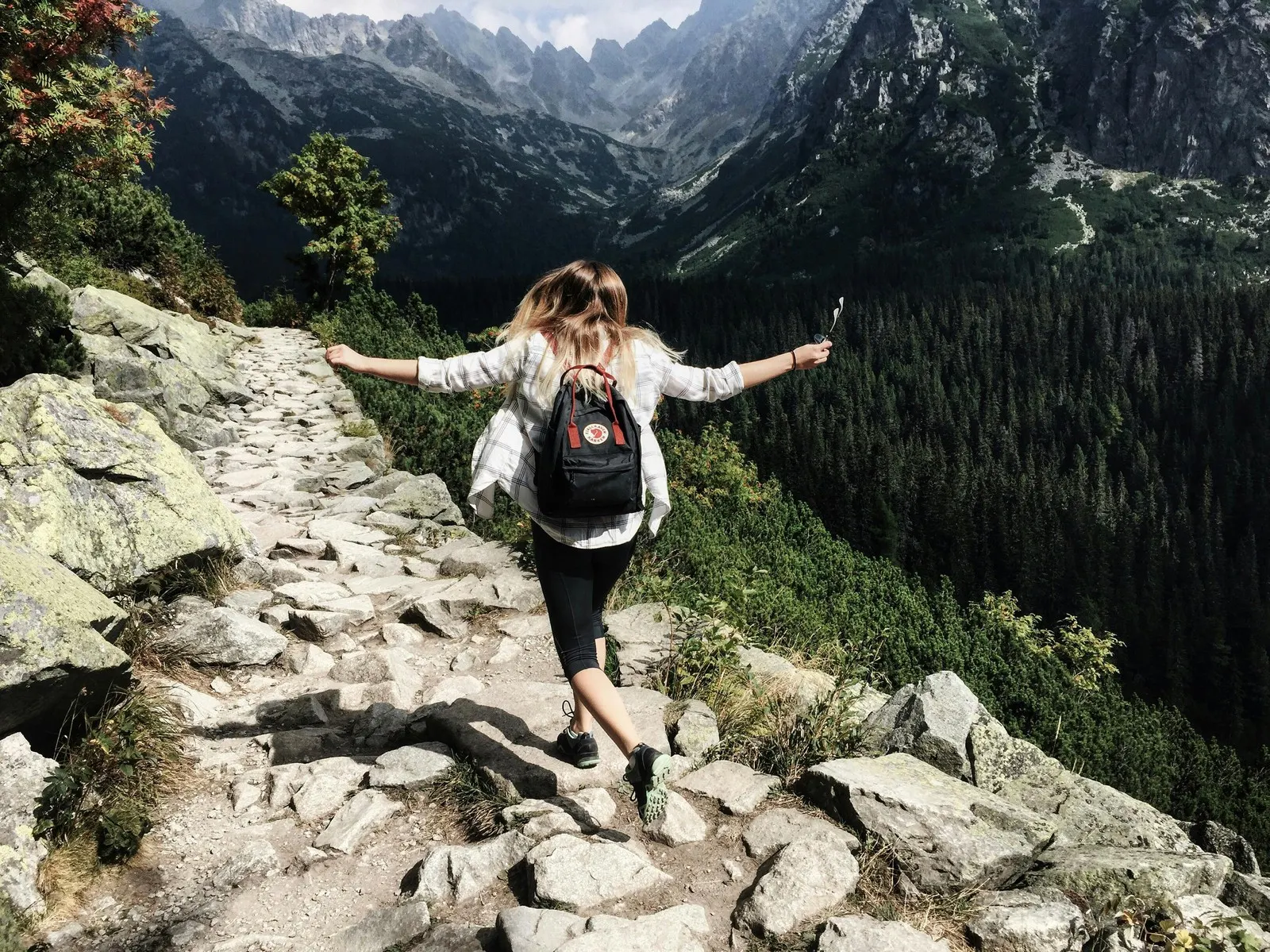 A woman walking on a mountain trail